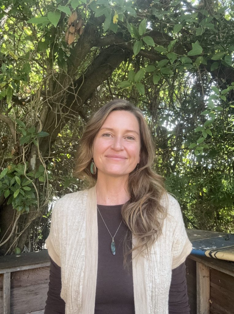 Jen Poole, LMFT, smiling outdoors beneath a leafy tree in Berkeley
