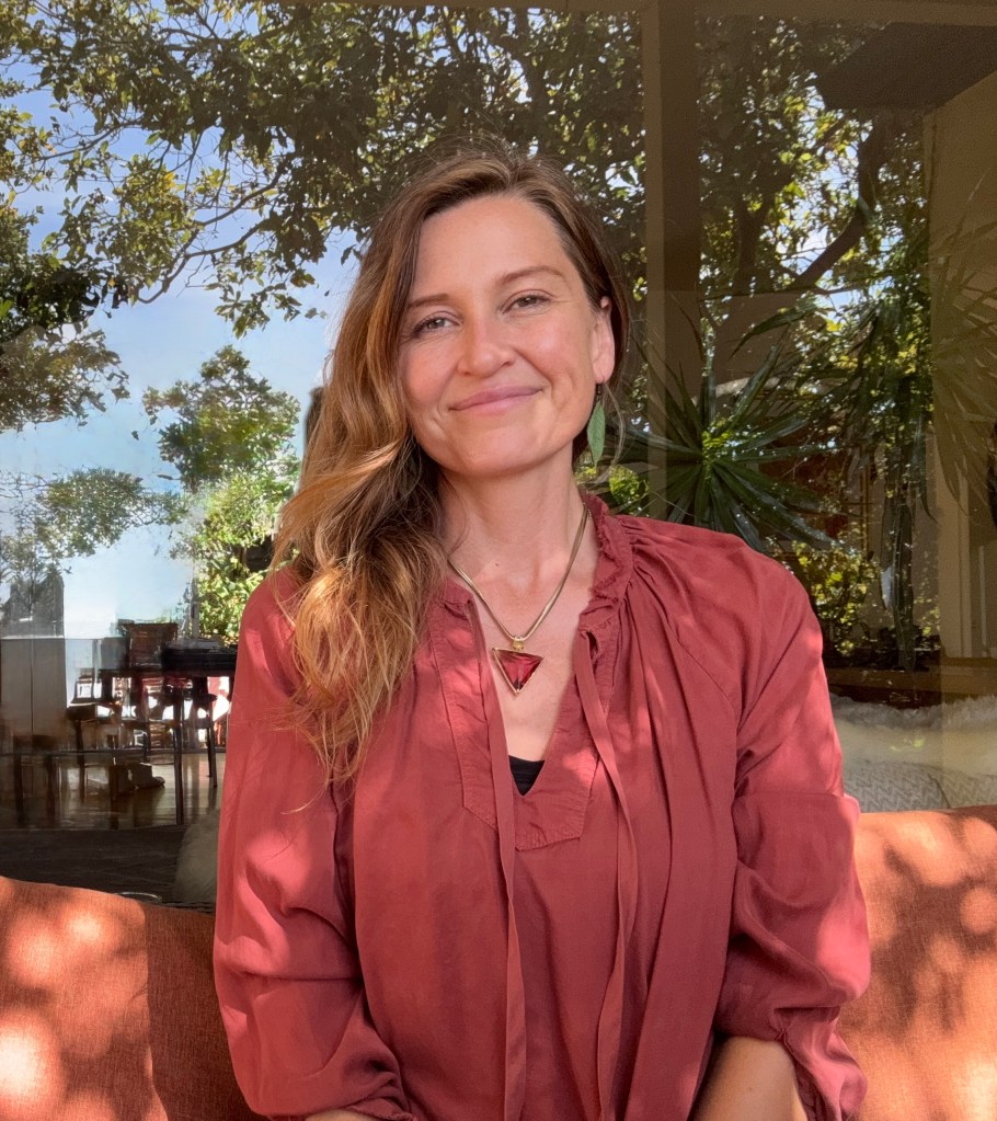 Jen Poole, LMFT, smiling in a rust-colored blouse beside a sunlit window